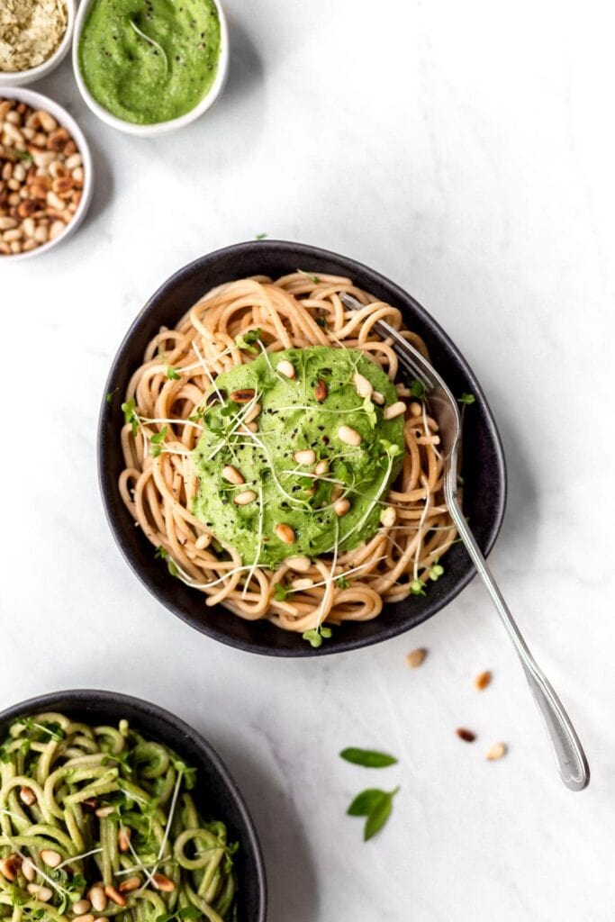A bowl of spaghetti covered in creamy green sauce. 