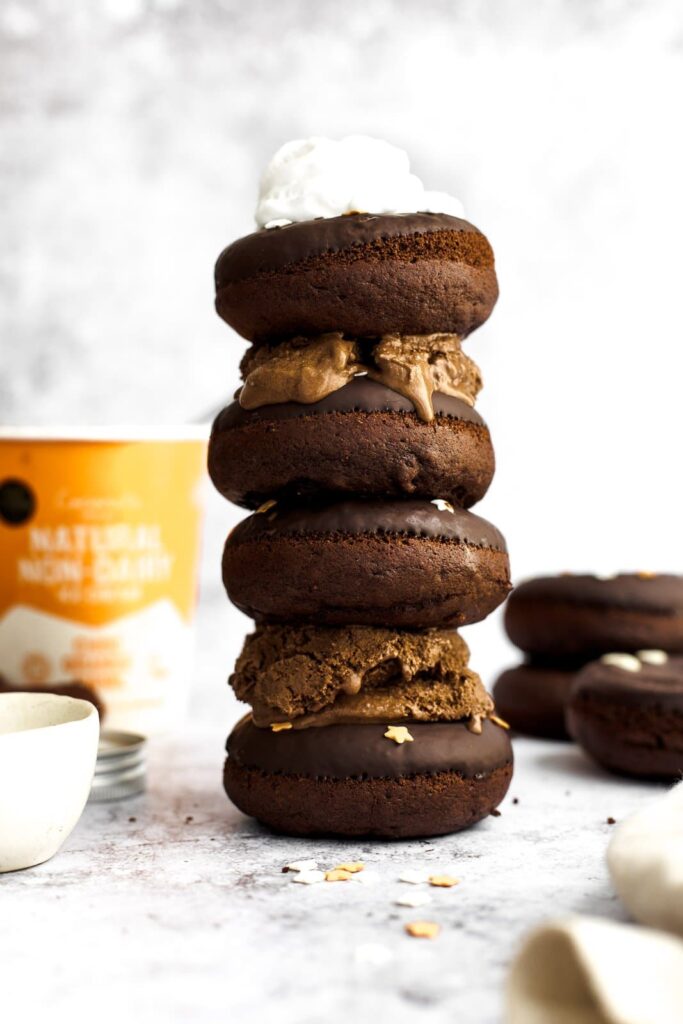 A large stack of chocolate donut ice cream sandwiches