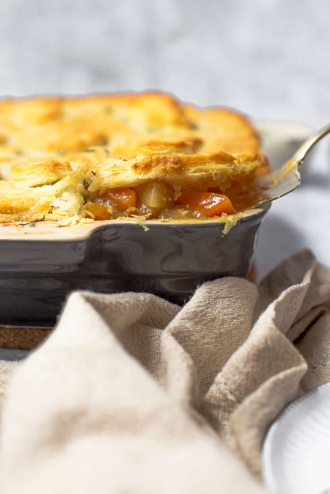 A slice of vegan pie being taken out of the oven dish.