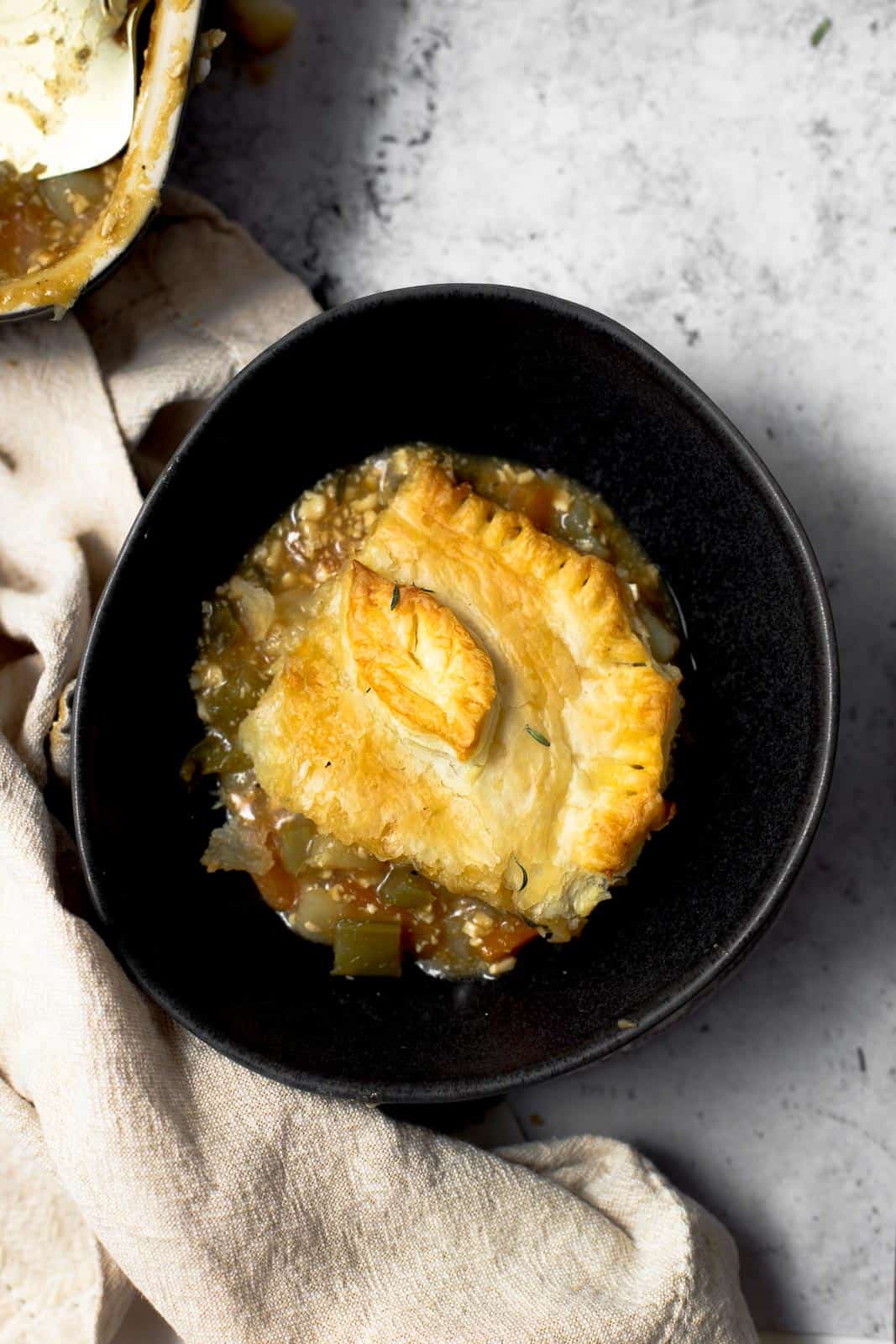 A slice of vegan pie in a large dark bowl.