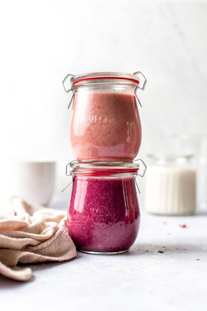 Two airtight jars containing smoothies stacked upon each other. 