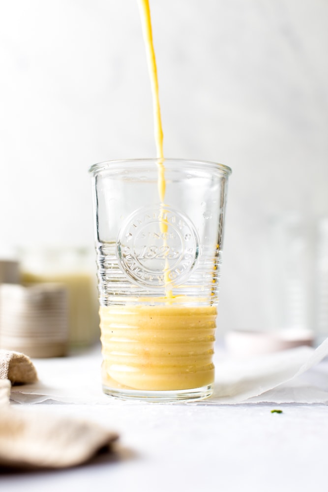 Coconut water smoothie being poured into a glass. 