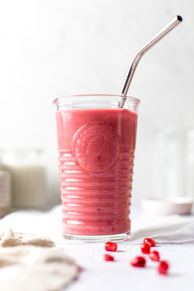 A full glass of pink pomegranate smoothie.