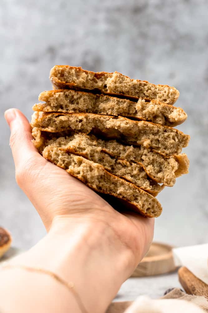 A hand holding a stack of oat milk pancakes.