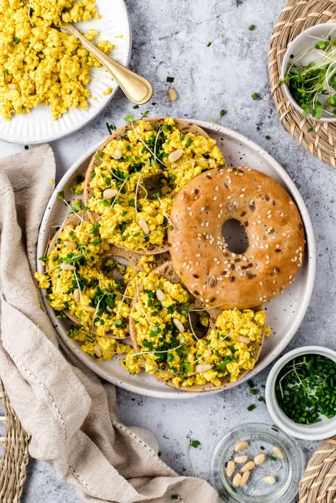 Bagels topped off with scrambled tofu and other toppings. 