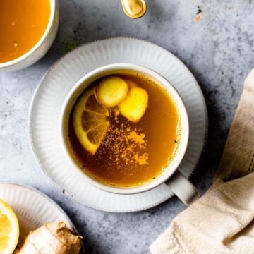A big mug of lemon tea placed on a saucer.