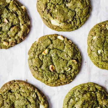 Six cookies placed on a parchment paper shown from the top.