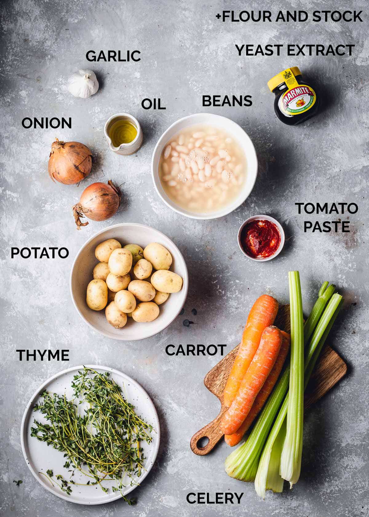 All the ingredient needed to make a vegetable stew laid out on a flat surface. 