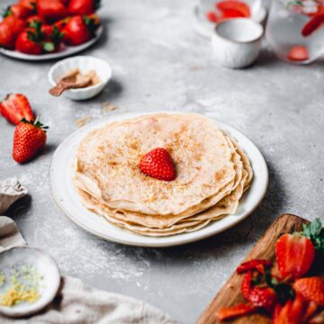 A side view of a plate featuring a stack of vegan almond milk crepes