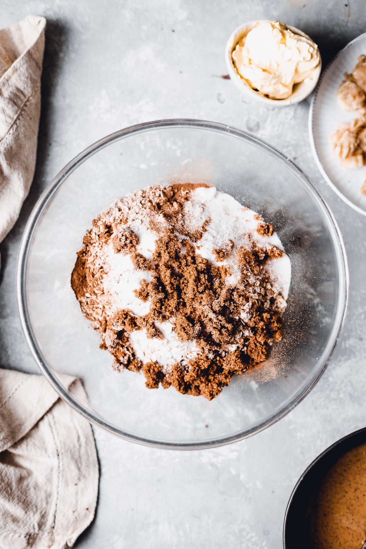 A large glass bowl full of various ingredients to make cookie dough.