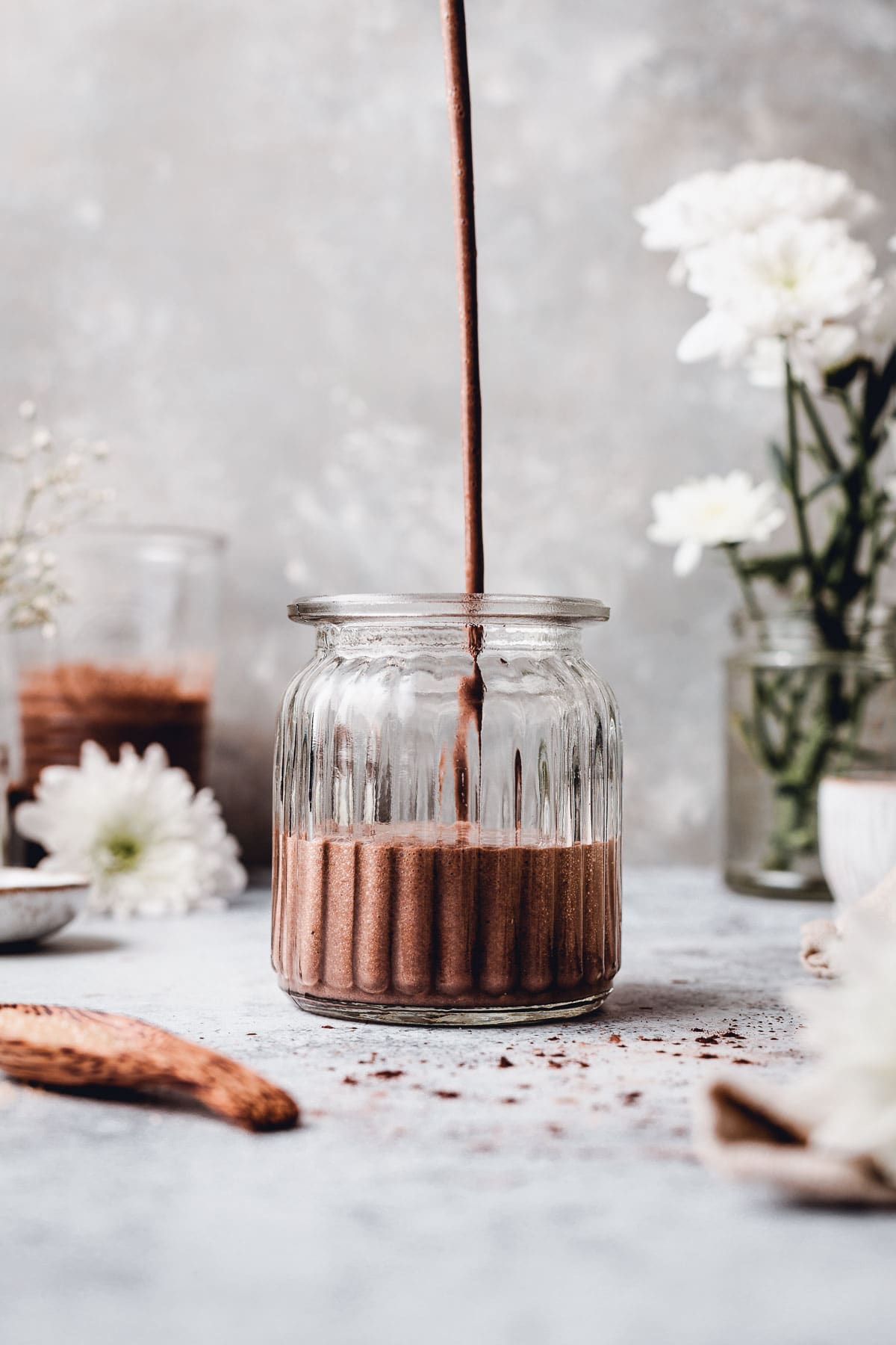 Chocolate milkshake being poured into a glass. 