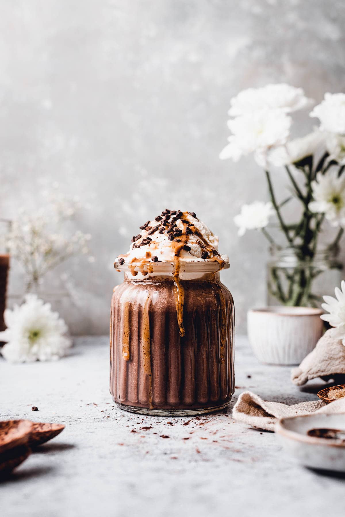 A ribbed glass full of chocolate milkshake topped off with ice cream. 