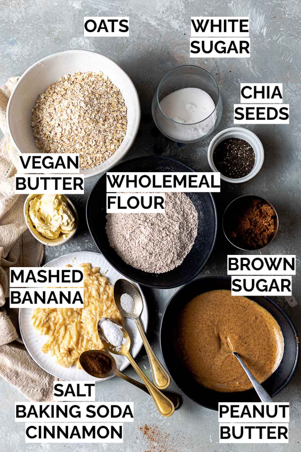 All ingredients needed to make oatmeal cookies laid out in bowls. 