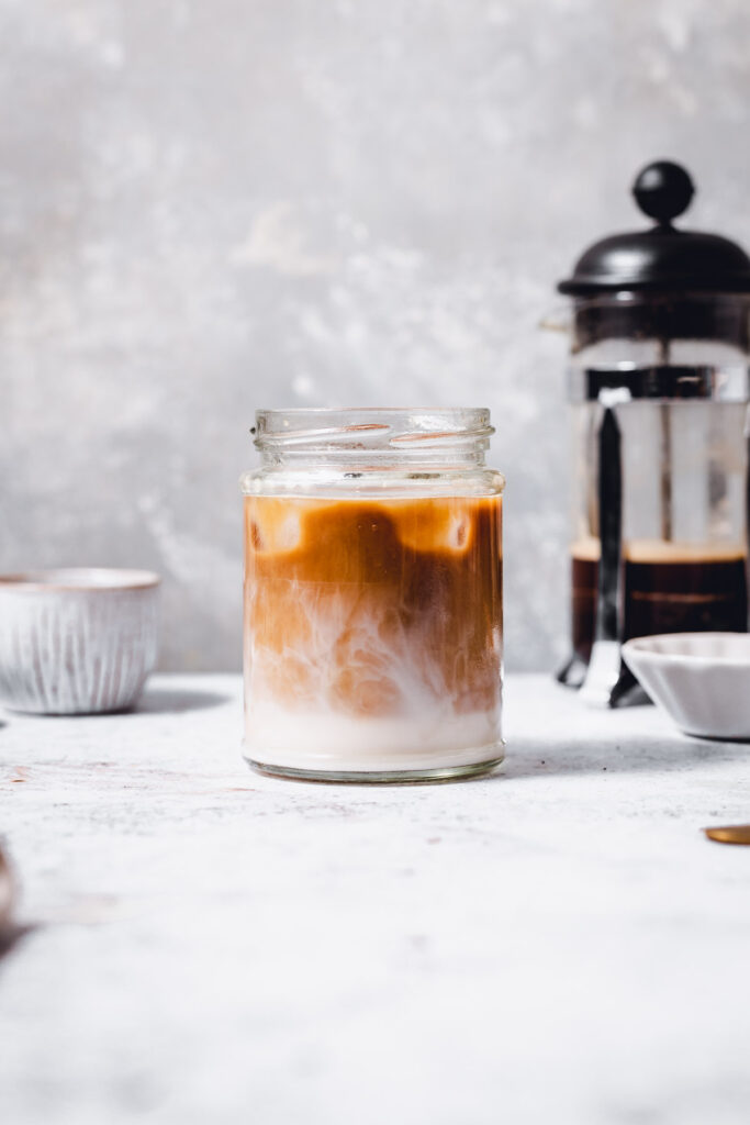 A glass filled with swirling iced coffee. 