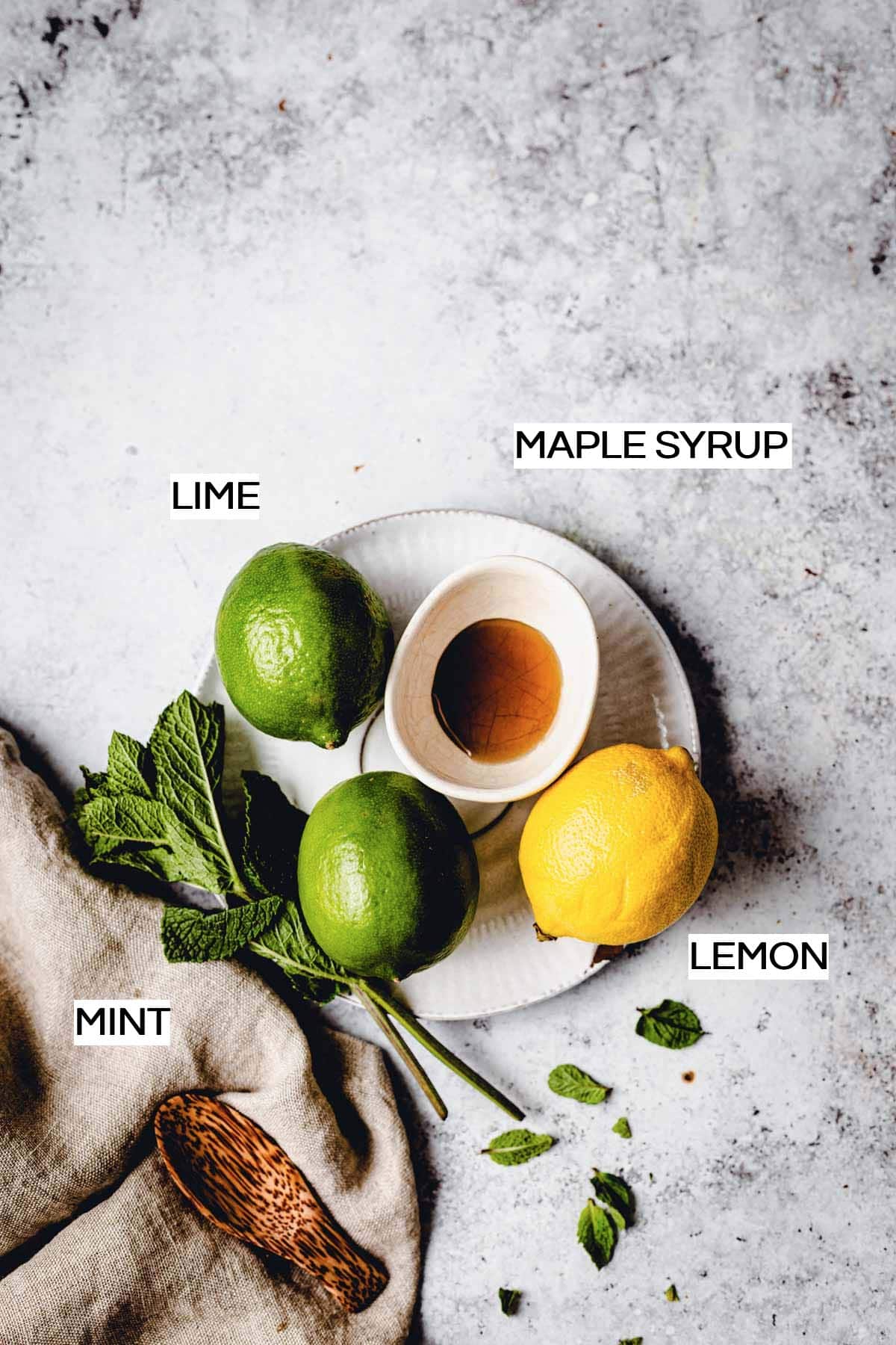All the ingredients needed to make lime popsicles laid out on a grey surface. 