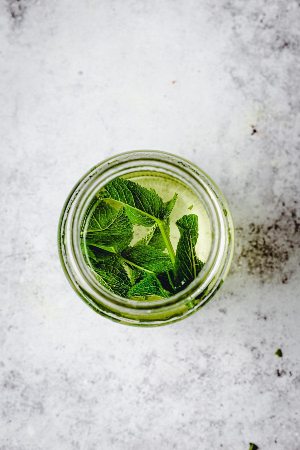 A large glass jar filled with fresh mint tea. 