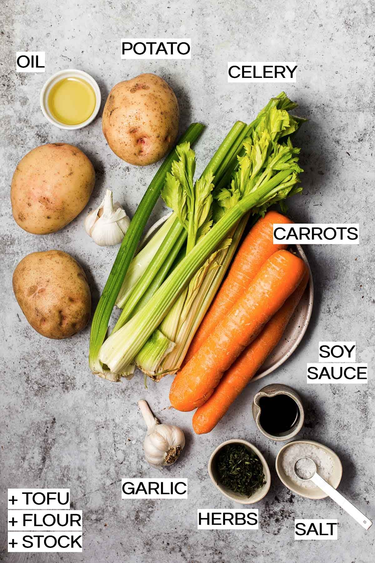 All the ingredients needed to make vegan pot pie laid out on a grey surface. 