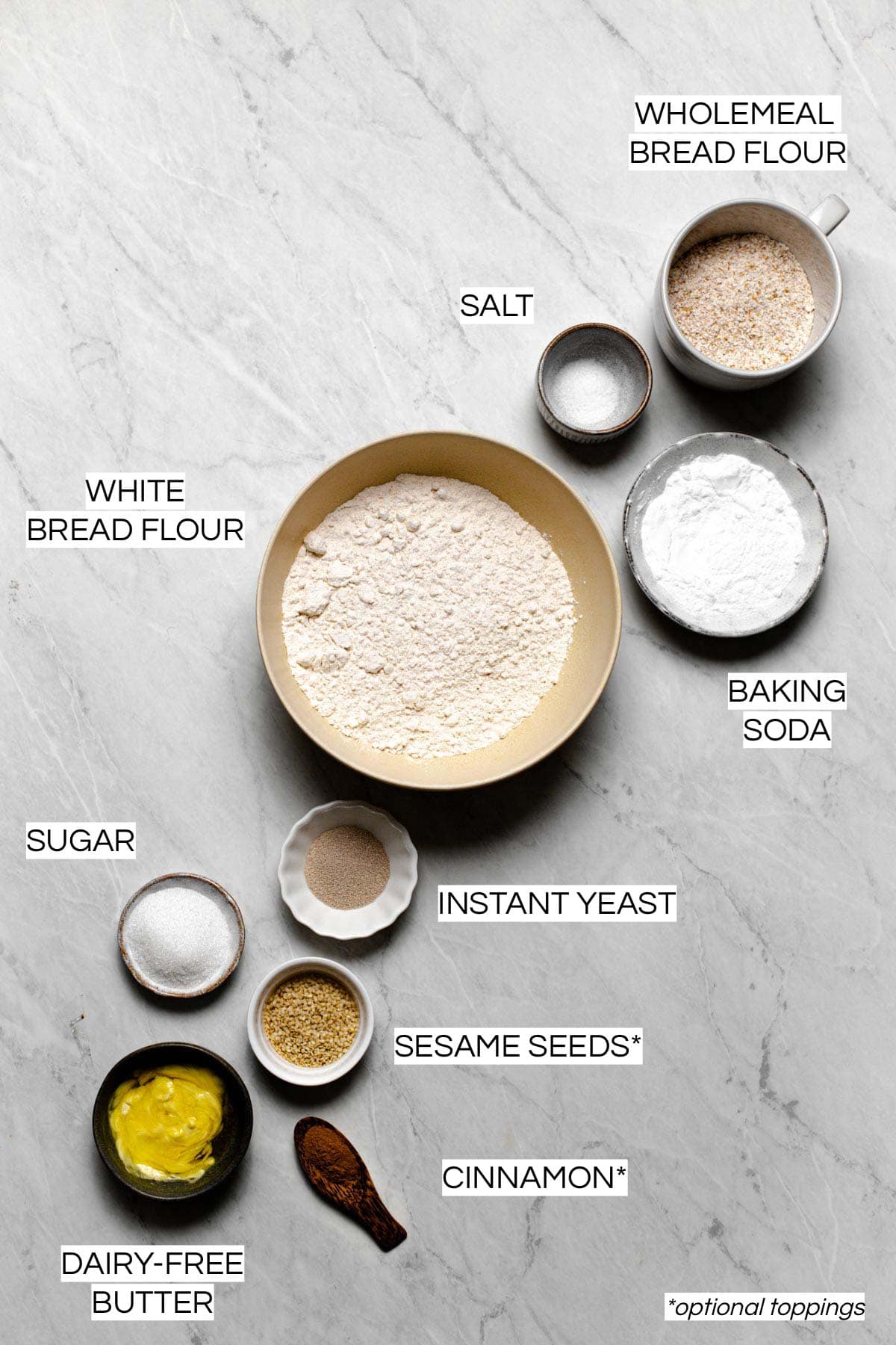 All the ingredients needed to make vegan pretzels on a marble surface. 