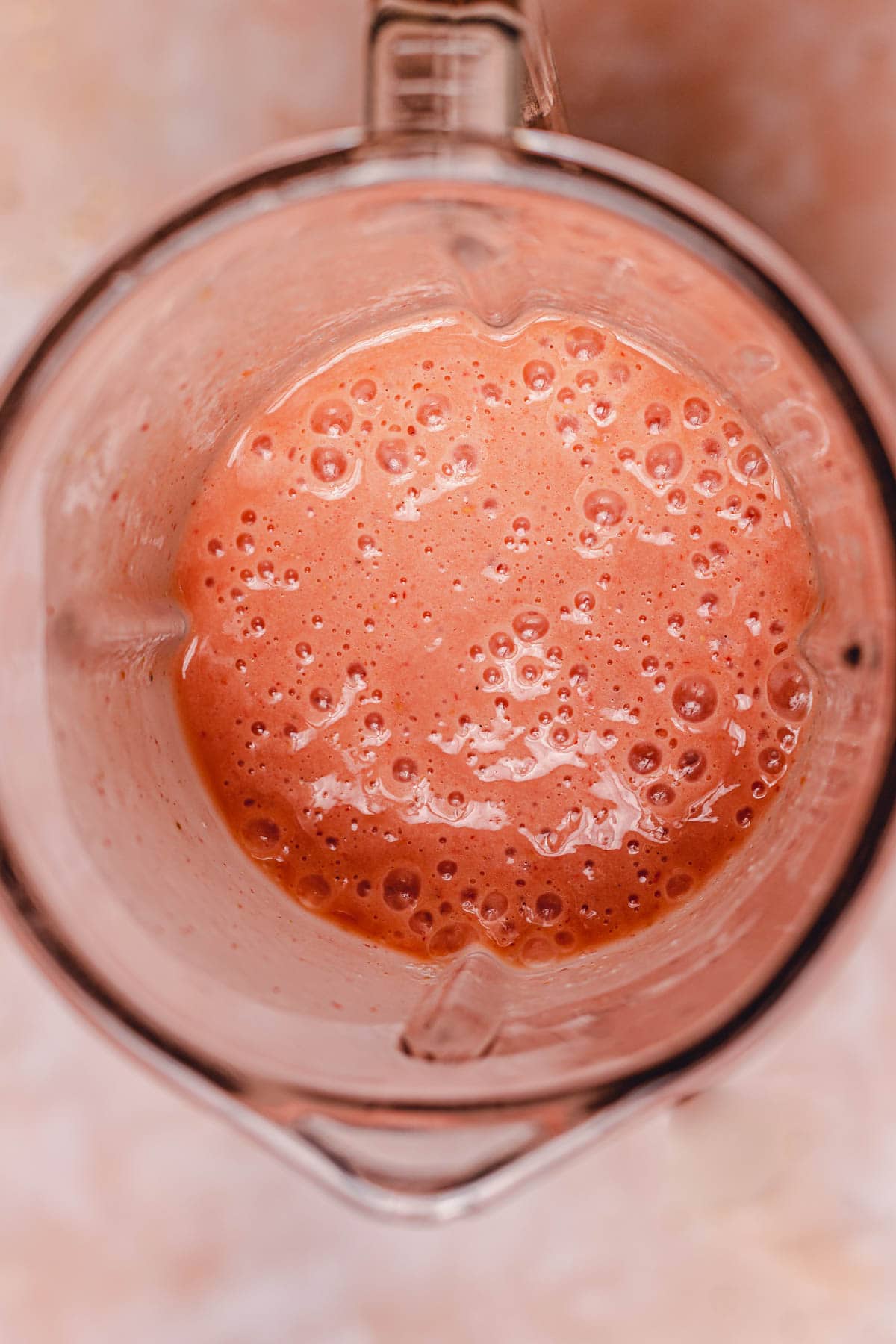 An overhead view of a blender with freshly made smoothie inside.