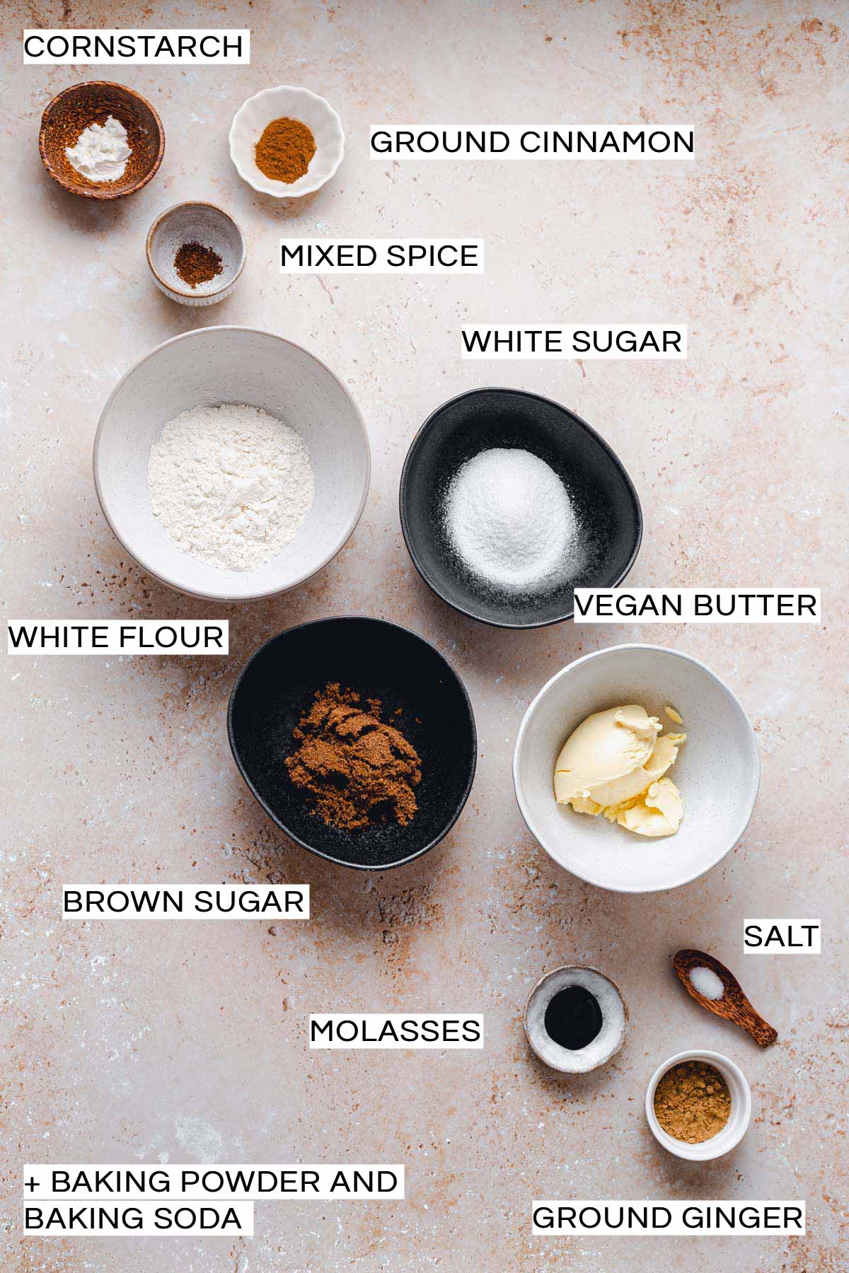 Various ingredients needed to make vegan ginger cookies placed on a flat surface.