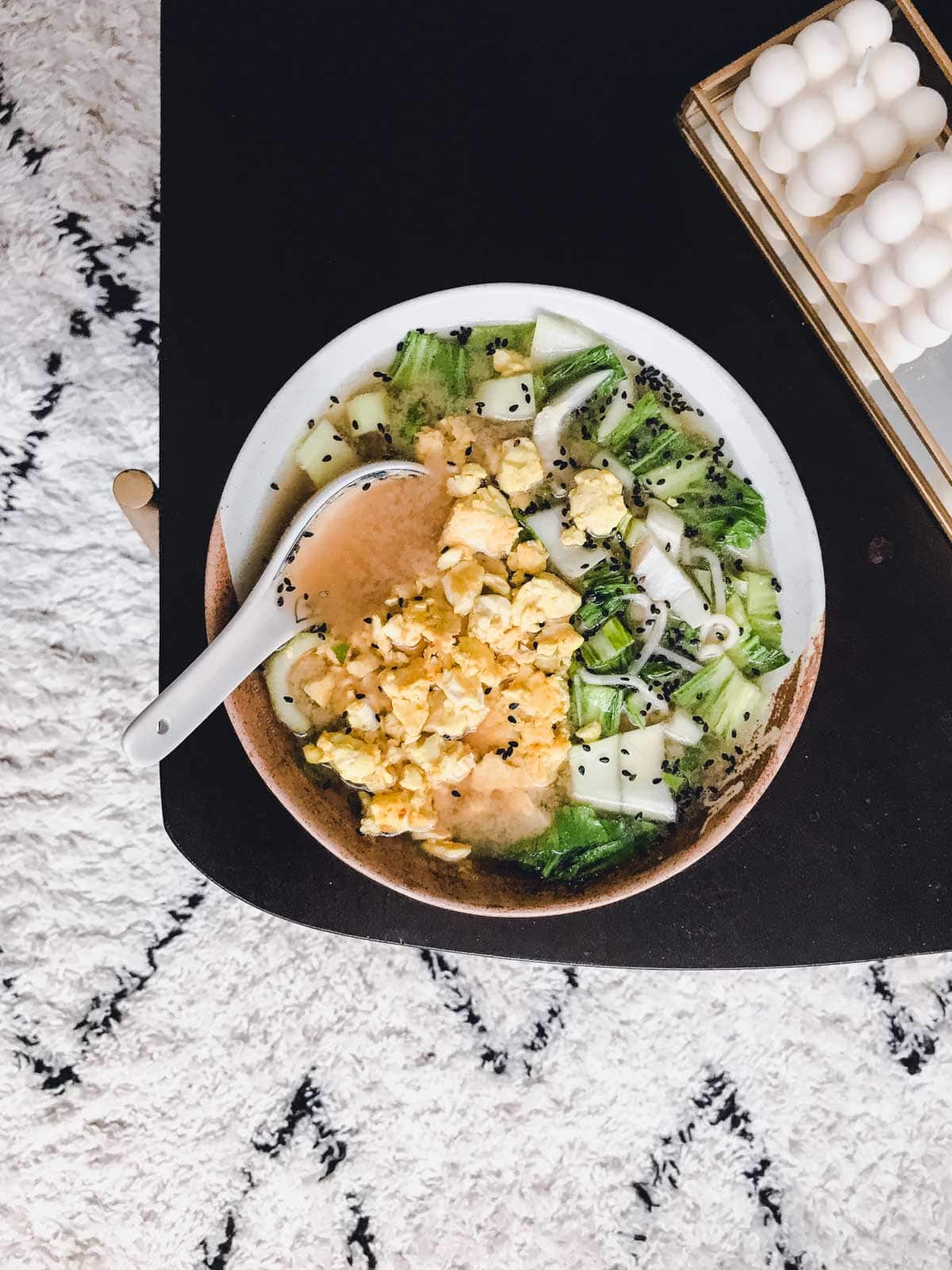 An image of a miso soup bowl placed on a wooden table. 