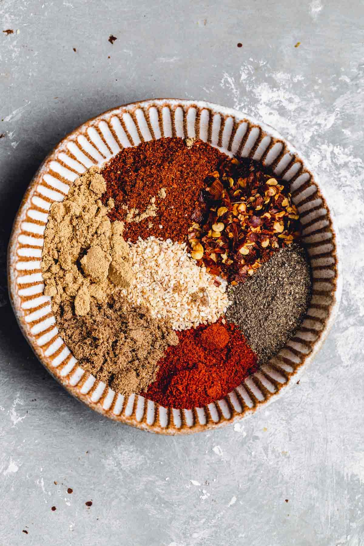 An overhead view of a small bowl filled with various spices.