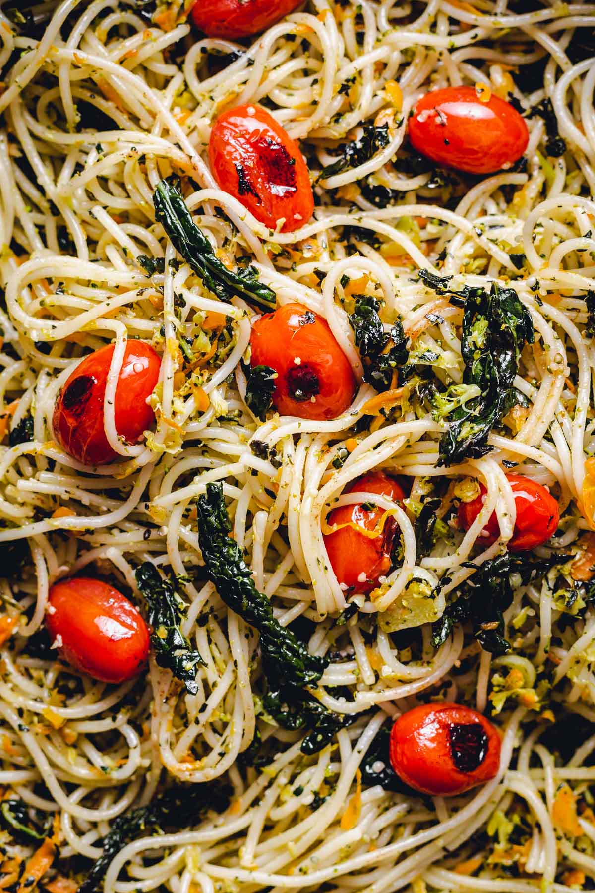 A close-up image of vegan spaghetti with Tuscan kale & tomatoes.