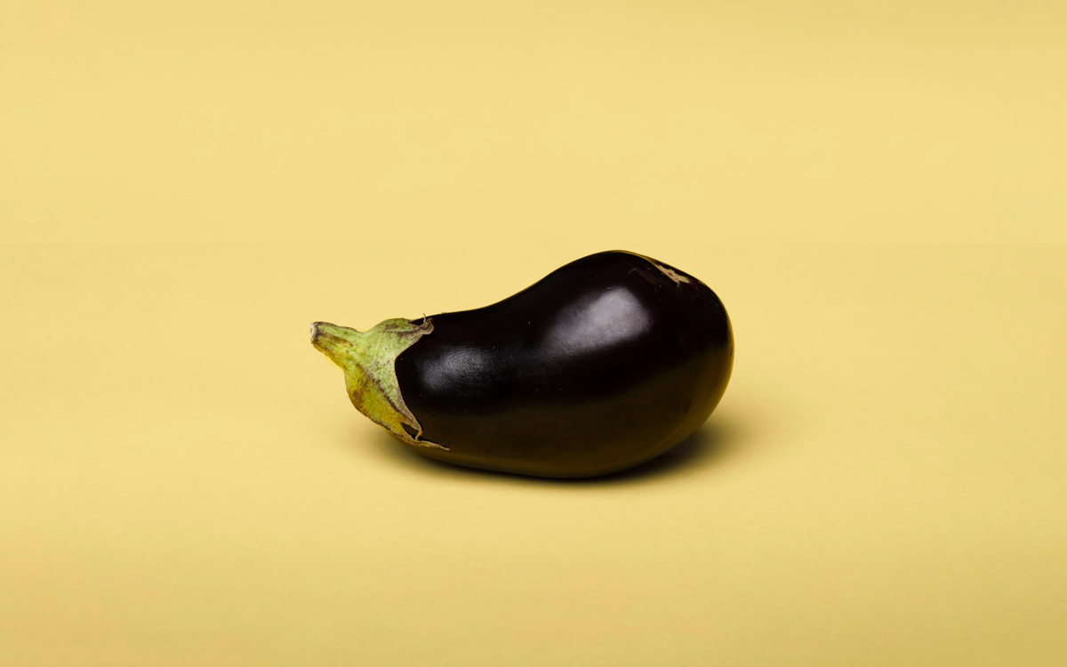 Aubergine on a plain yellow background.