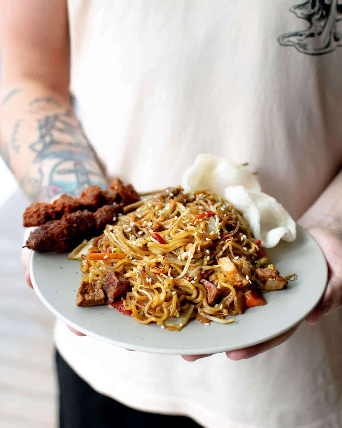 Two hands holding easy vegan mi goreng. 