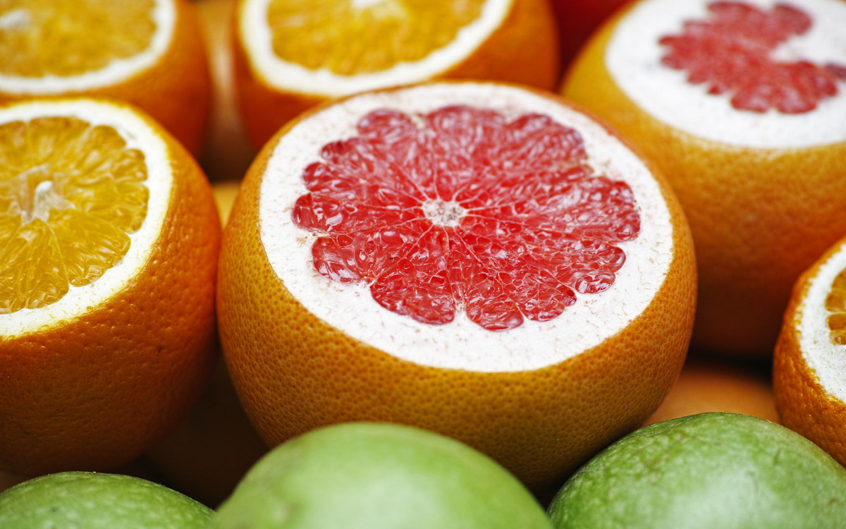 Pomelo fruits sliced open and placed next to each other.