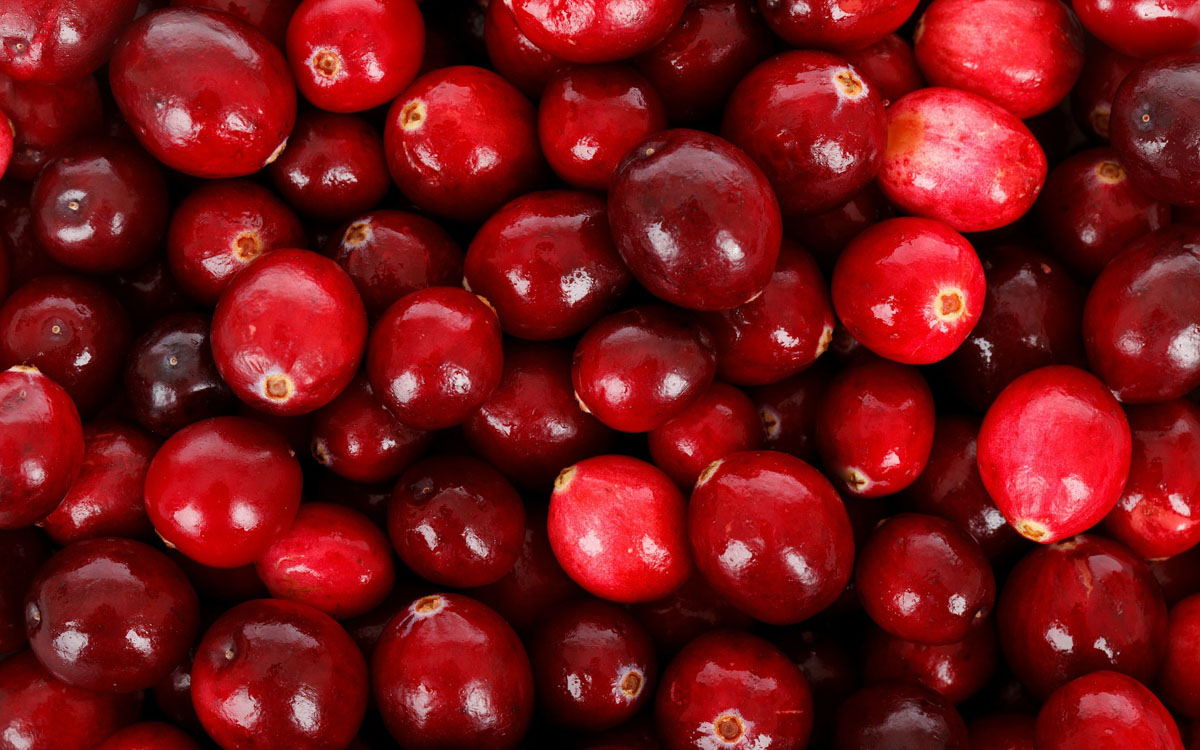 A close-up image of many cranberries placed closely next to each other.