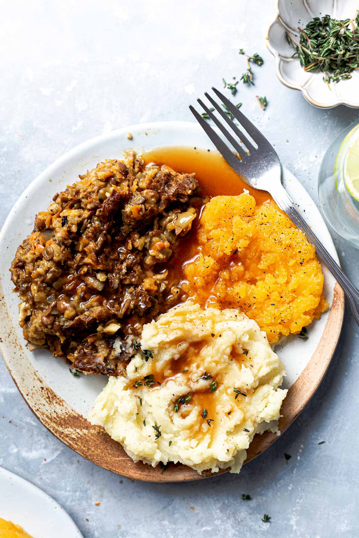 A plate featuring haggis, mashed potato, and mashed turnip with gravy.