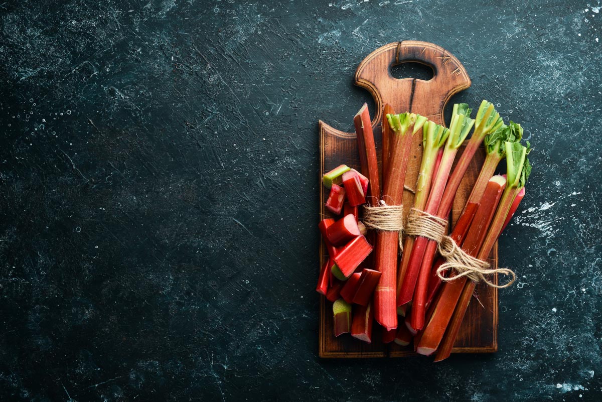 Chopped fresh rhubarb on a black stone background. Top view.