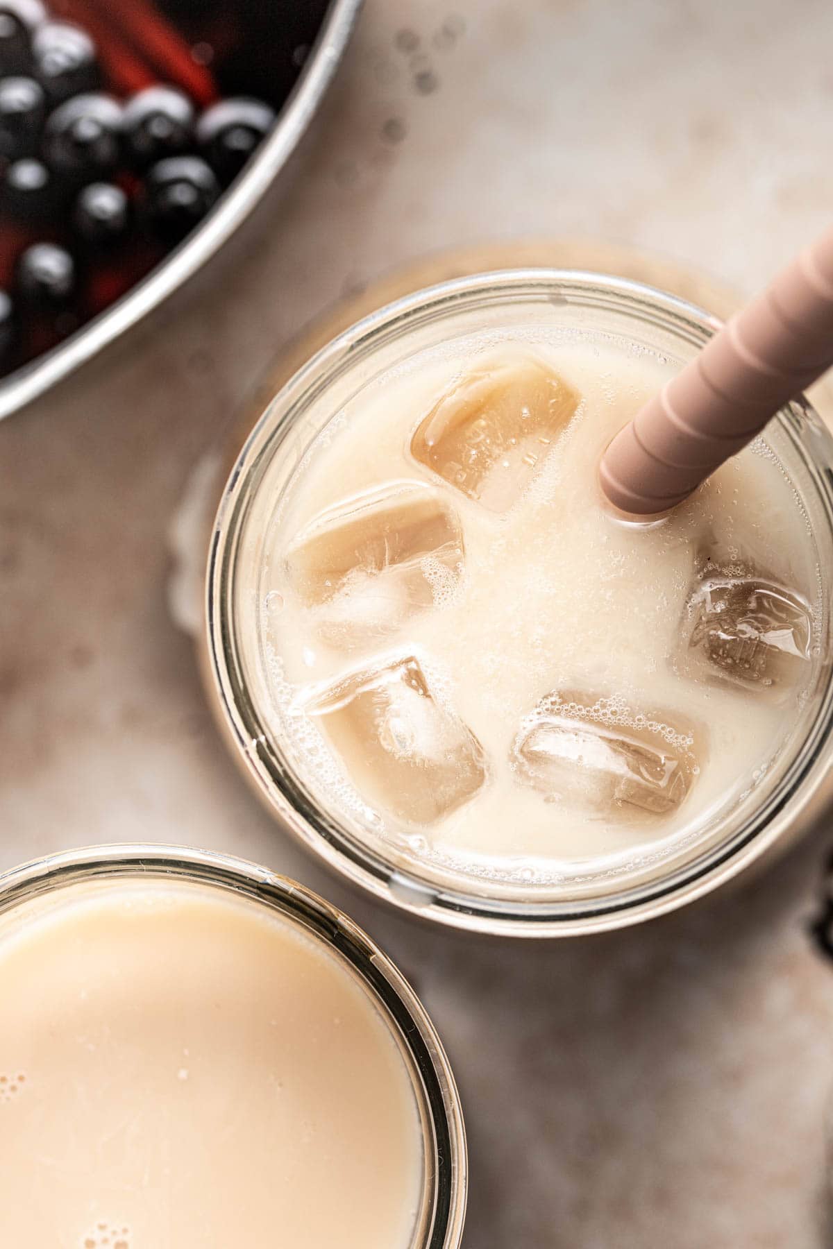 A close-up overhead image of milk tea filled with ice cubes.