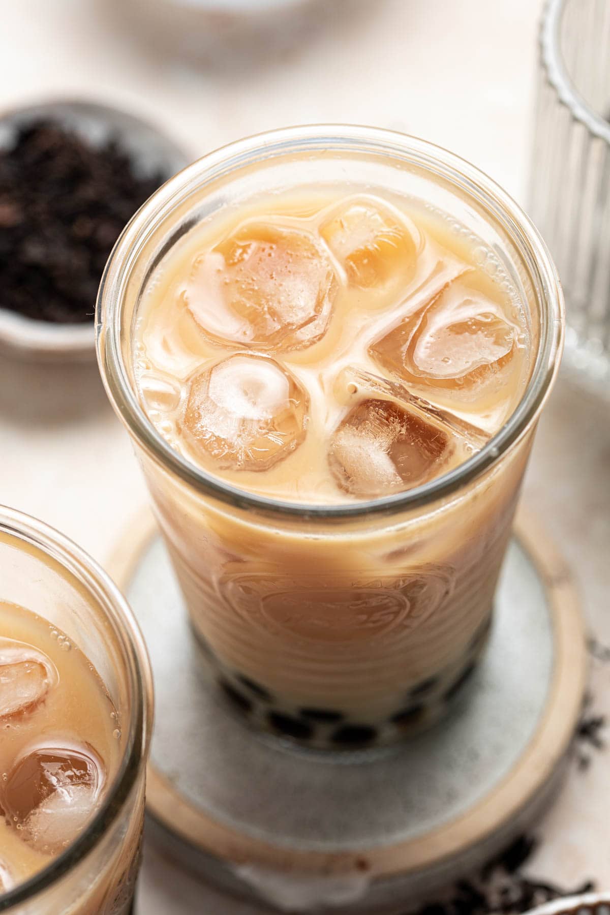 A glass filled with Oolong milk tea and many ice cubes.