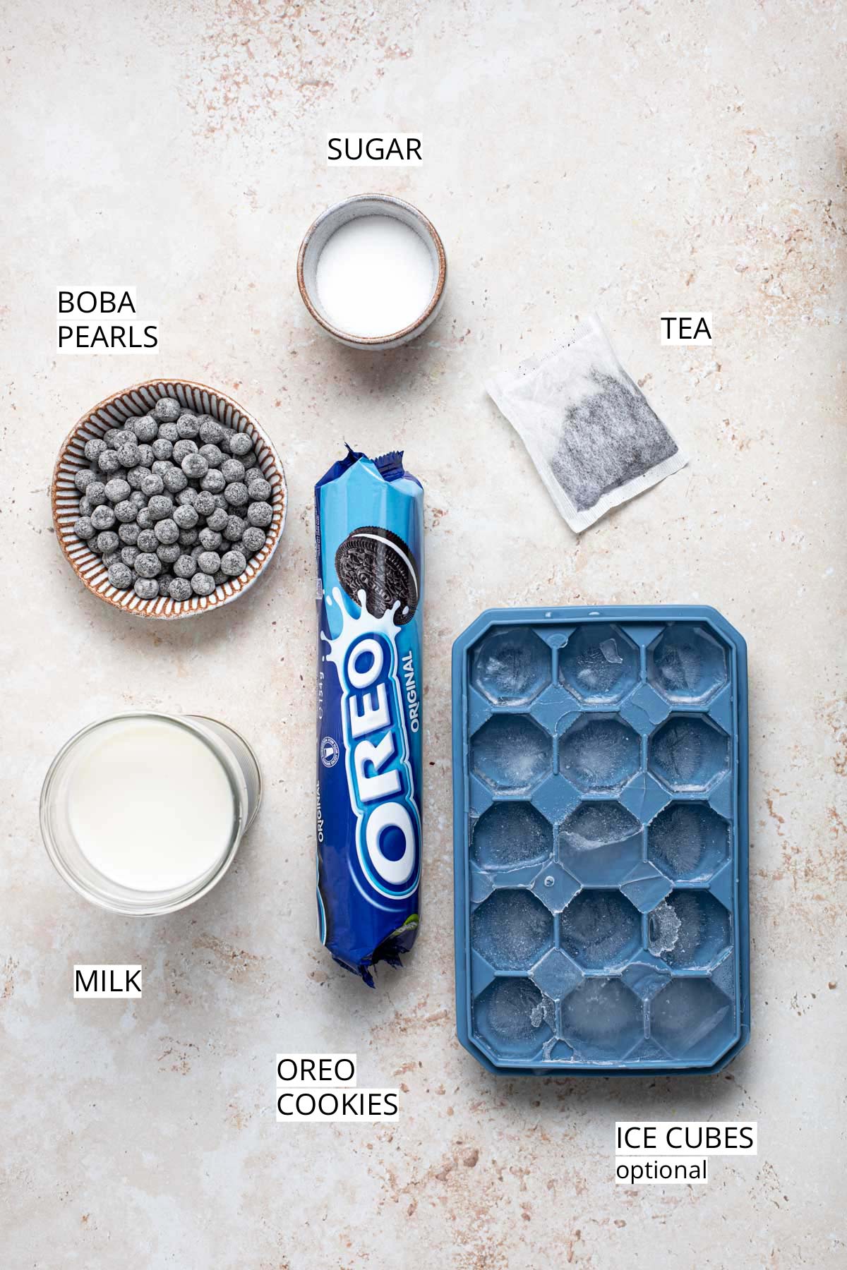All ingredients needed to make oreo milk tea placed on a flat surface.
