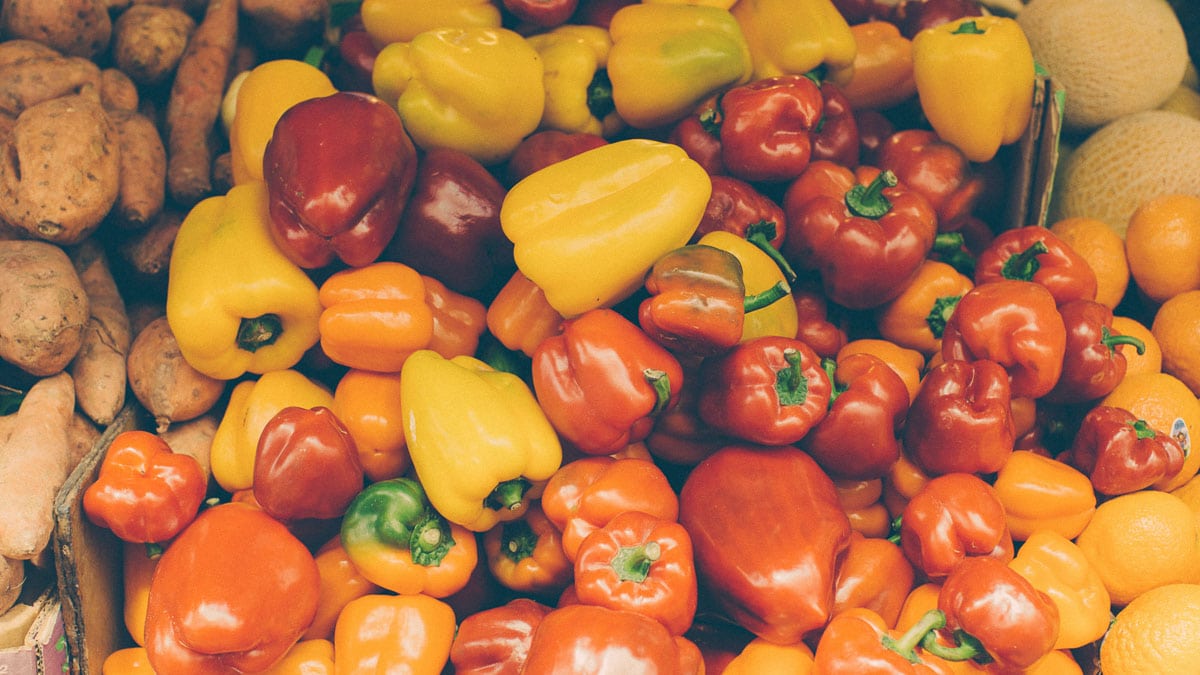 Various yellow and red peppers on a fruit stall.