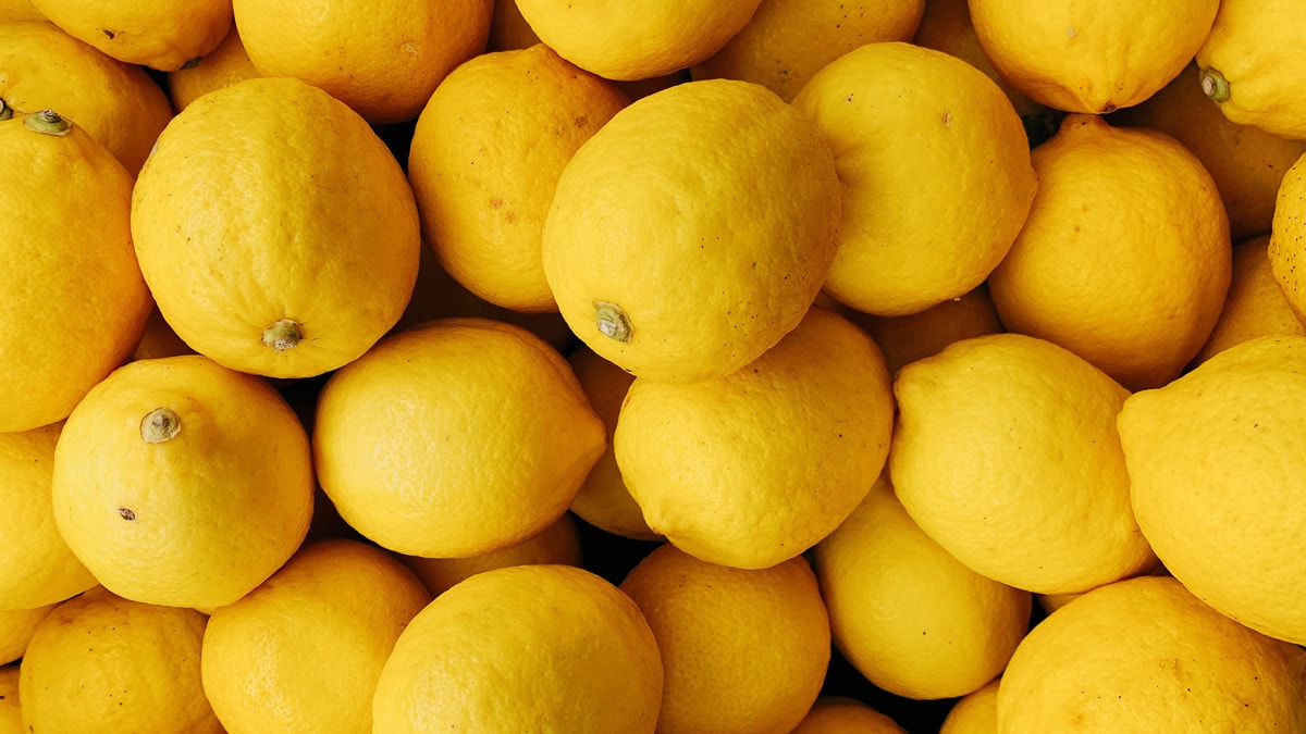 Overhead view of dozens of lemons placed on top and next to each other.
