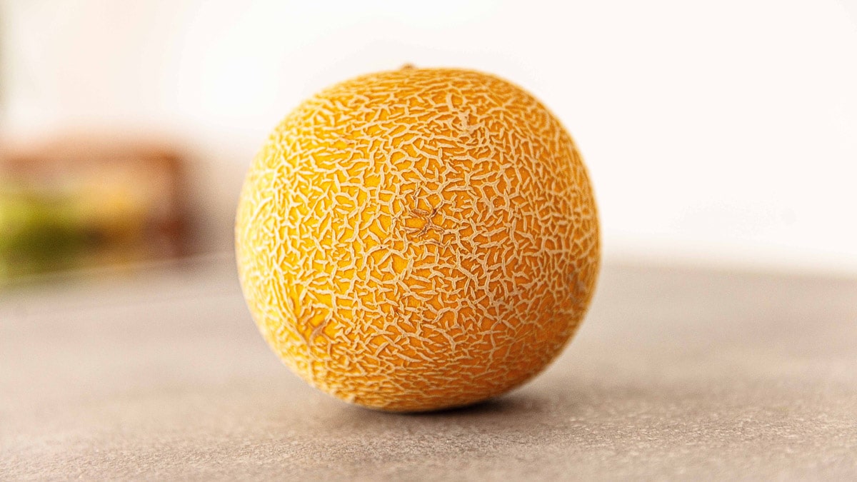 A single honeydew melon placed on a flat surface.