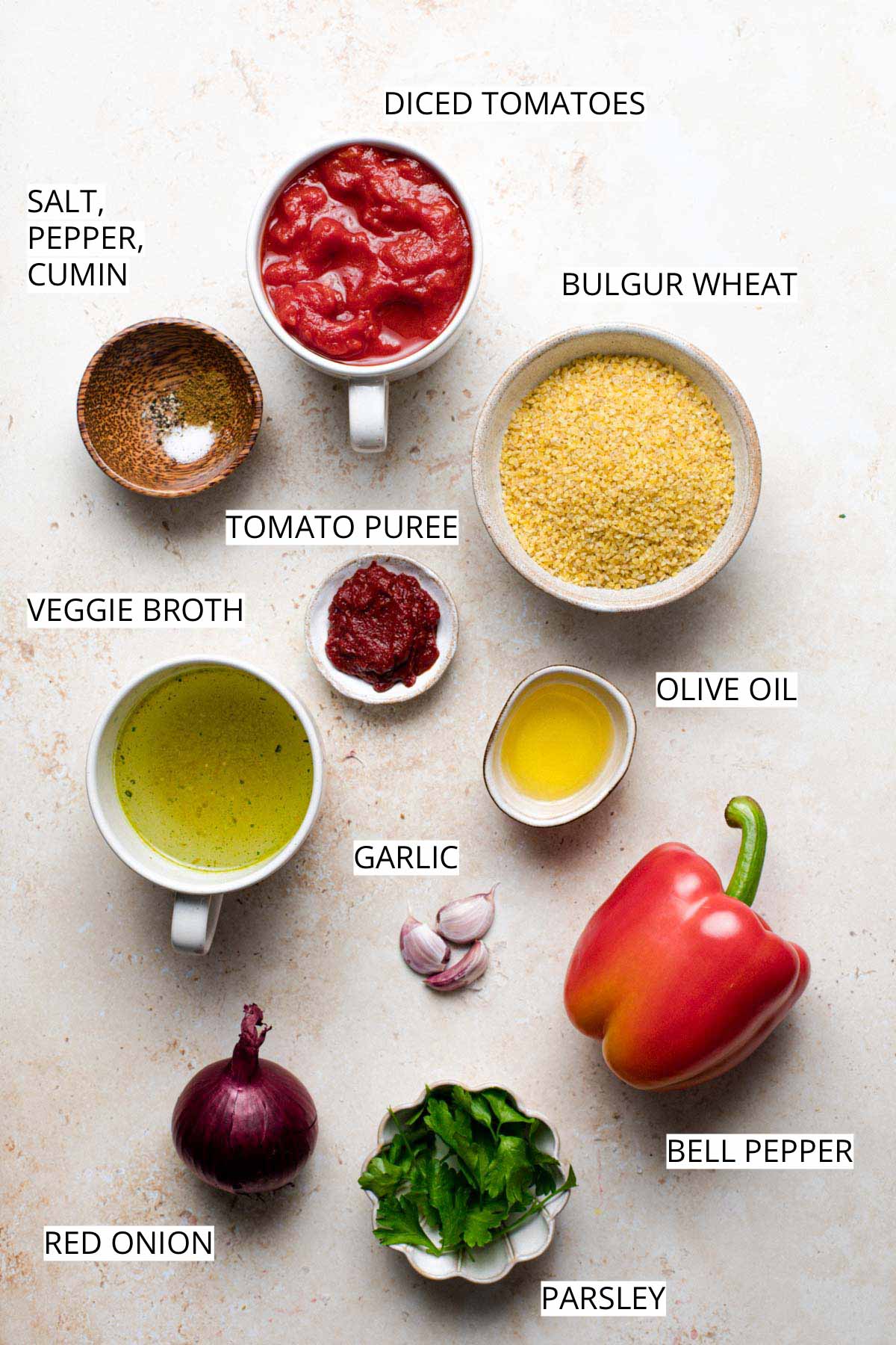 All ingredients needed to make bulgur pilaf laid out on a flat surface.