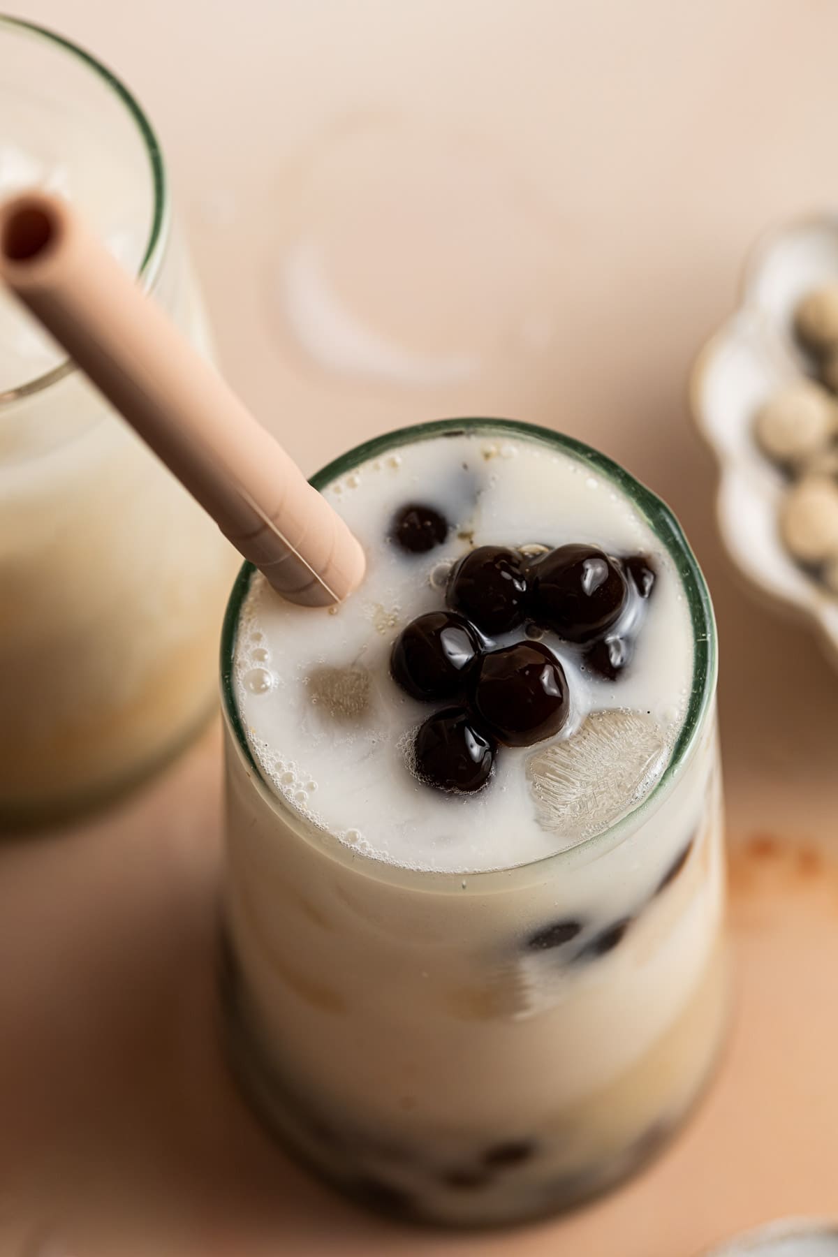 A side view of lychee milk tea served in a glass.