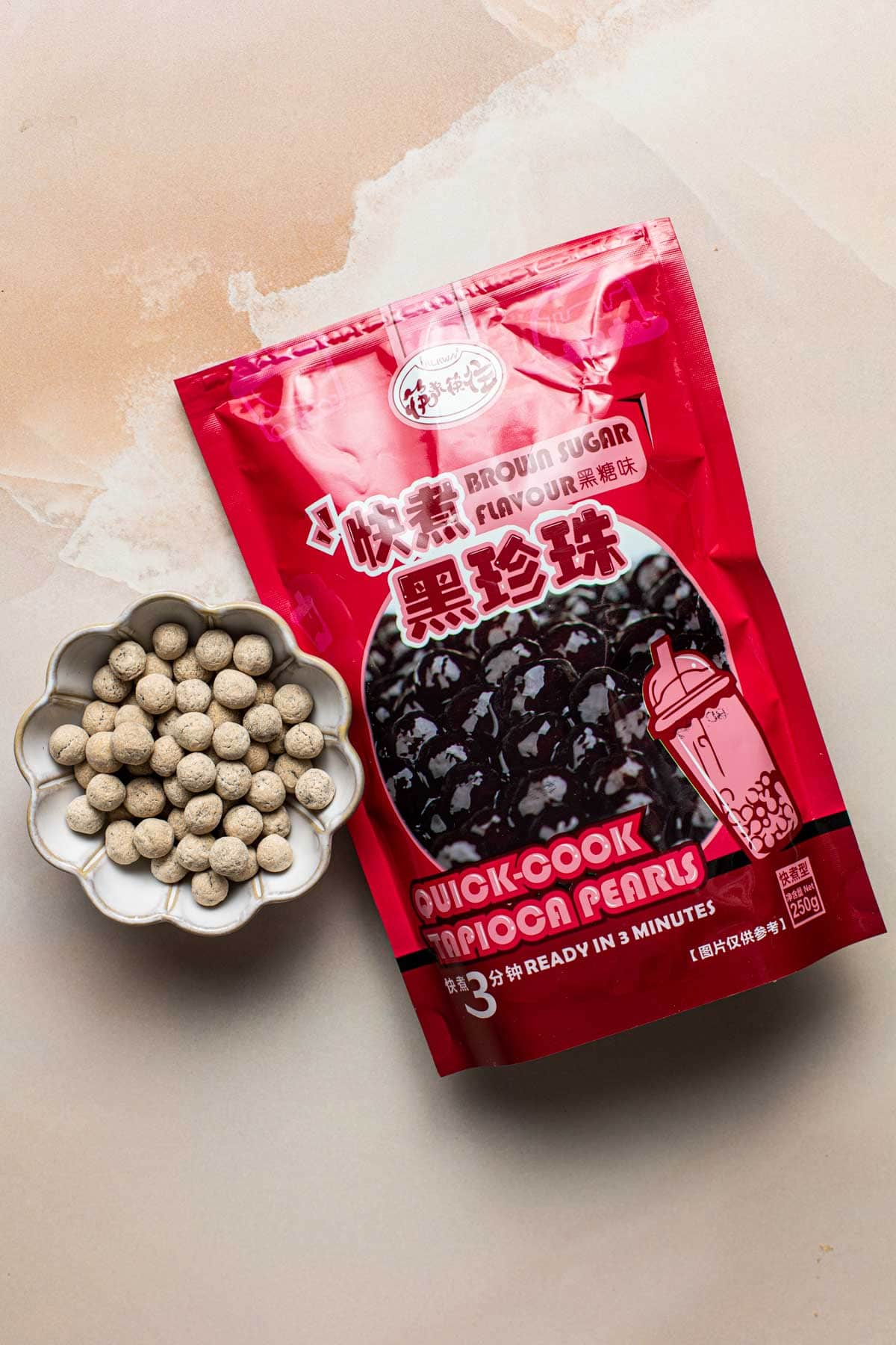 A flatlay showing black sugar tapioca pearls in and outside their packaging. 