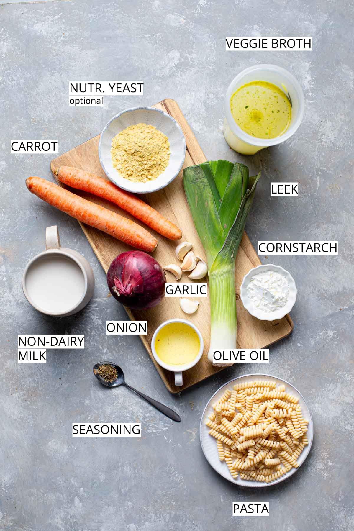 Ingredients needed to make vegan chicken soup placed on a chopping board.