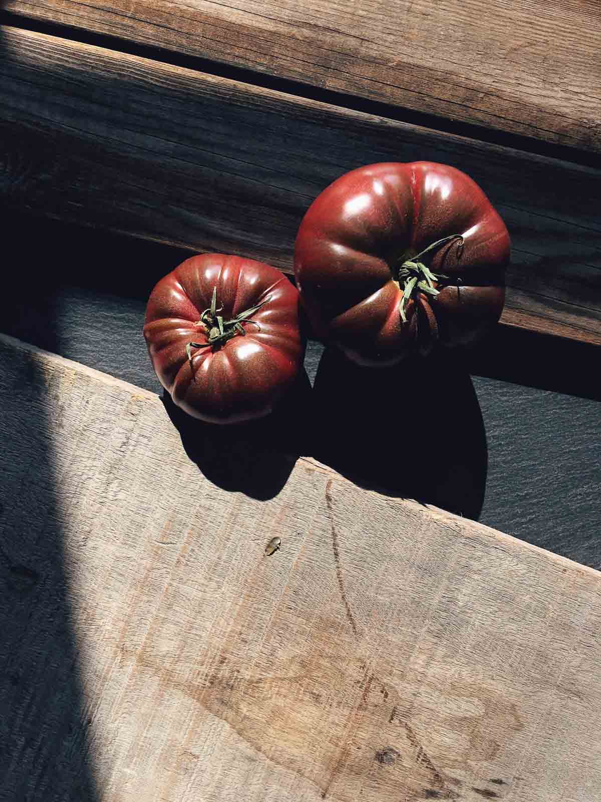 Directly above shot of two fresh Black tomatoes on wooden table