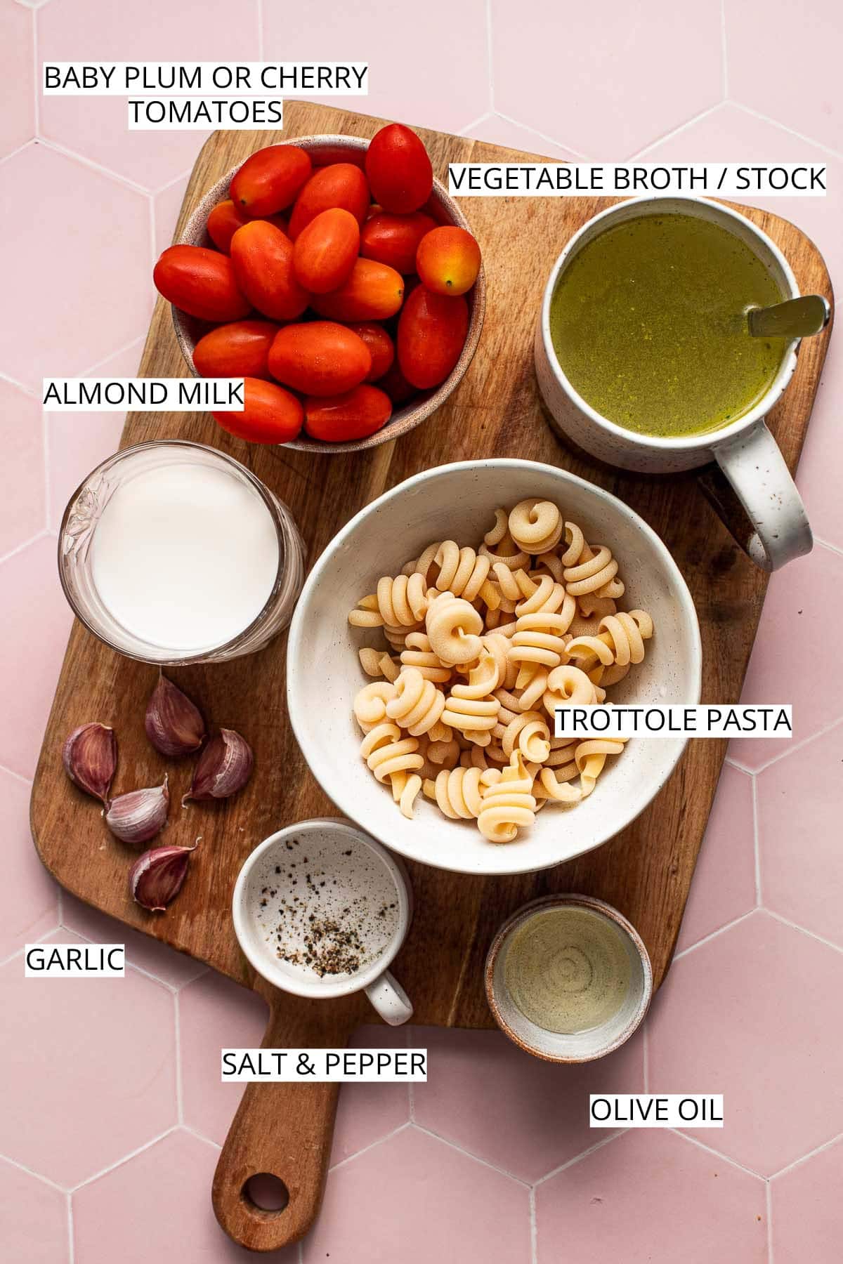 Various ingredients needed to make pasta sauce placed on a large chopping board. 