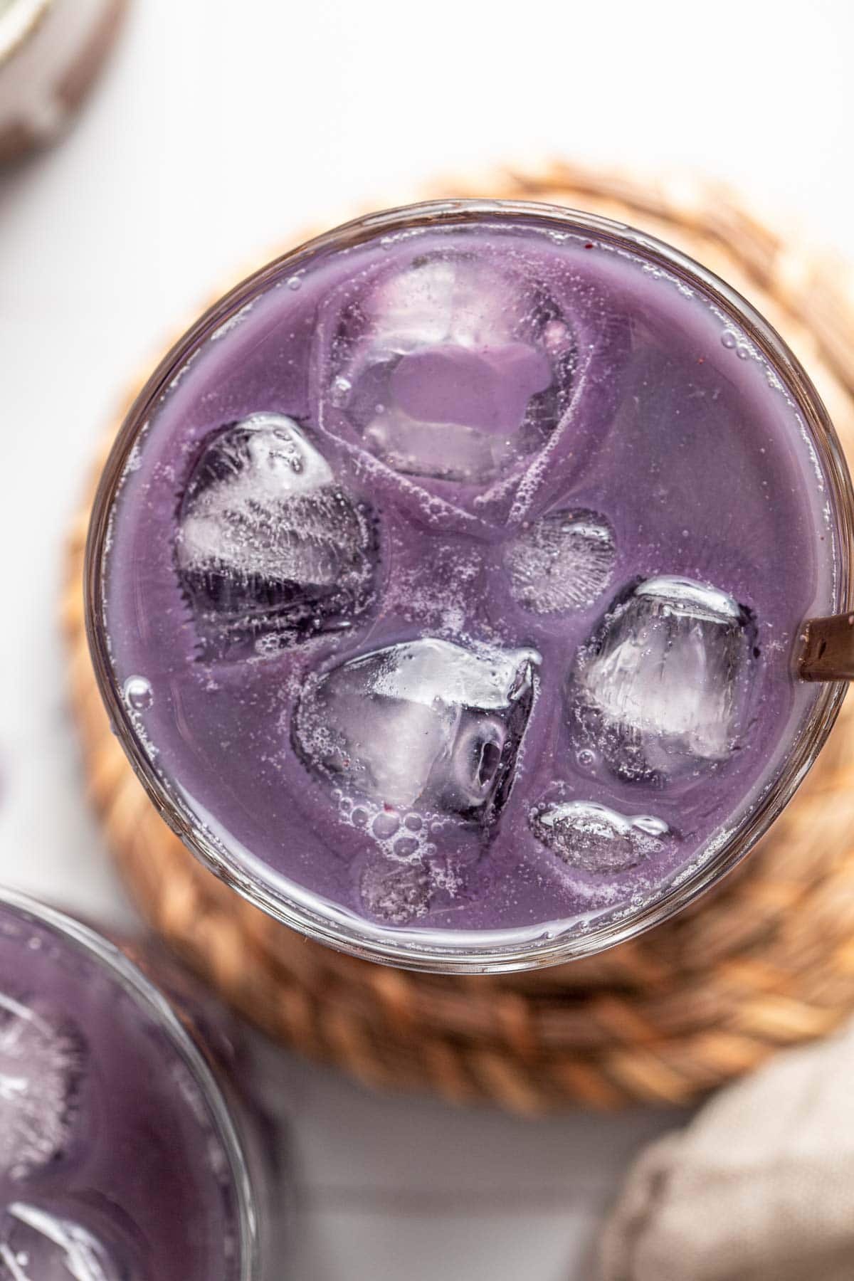 An overhead view of blueberry boba tea in a glass.