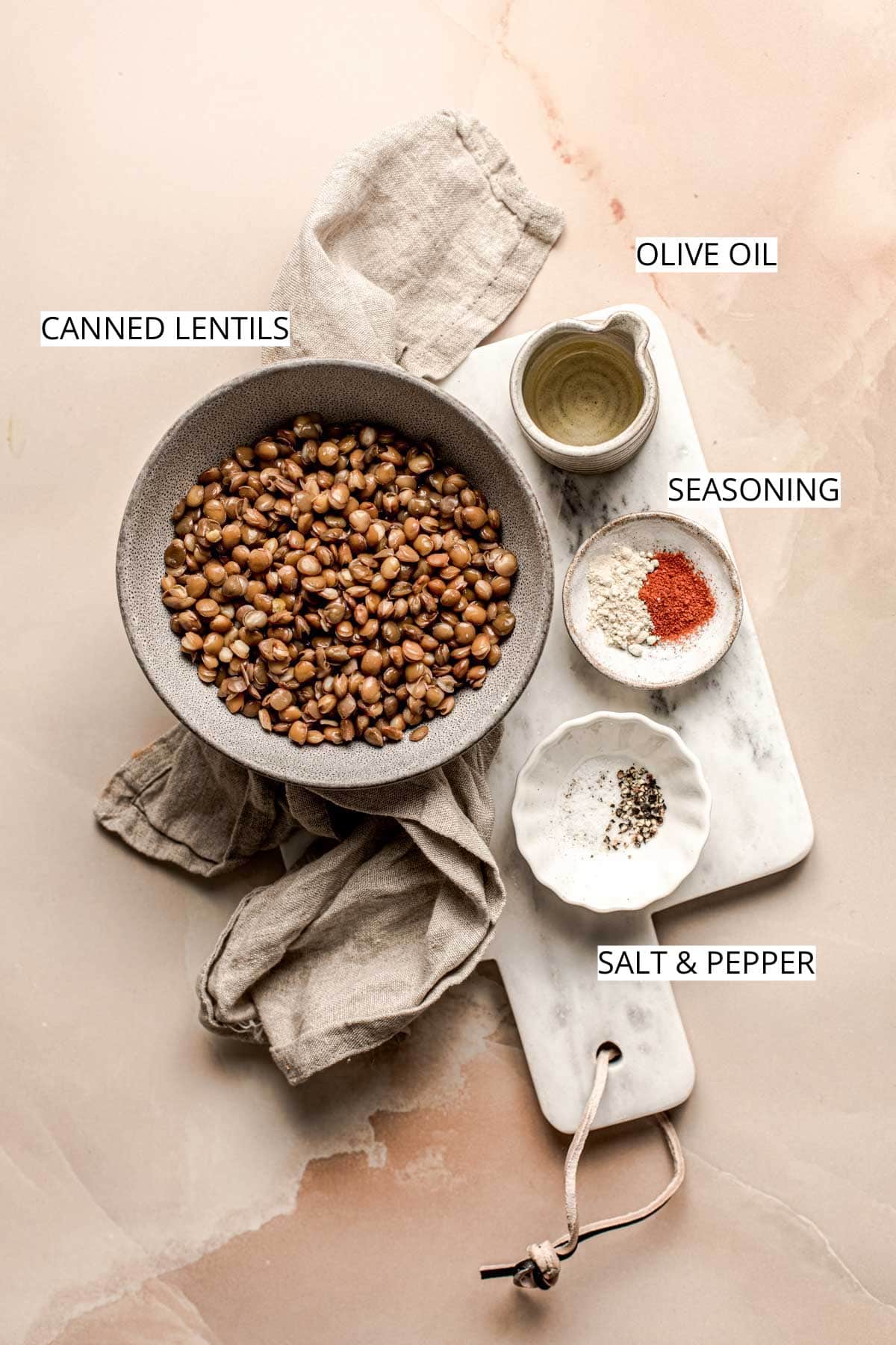 Lentils, olive oil, seasoning, salt and pepper on a marble board