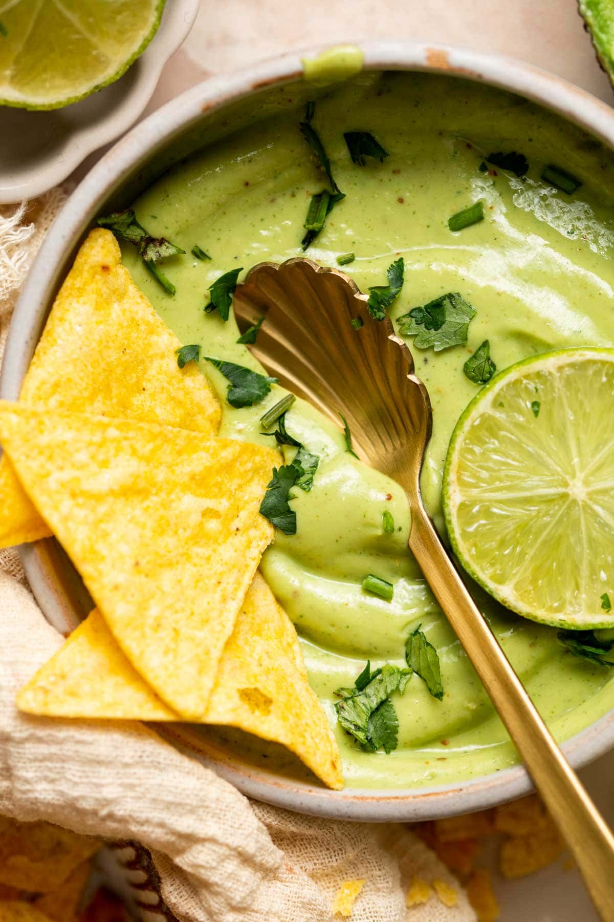 A close-up image of avocado crema served with tortilla chips.