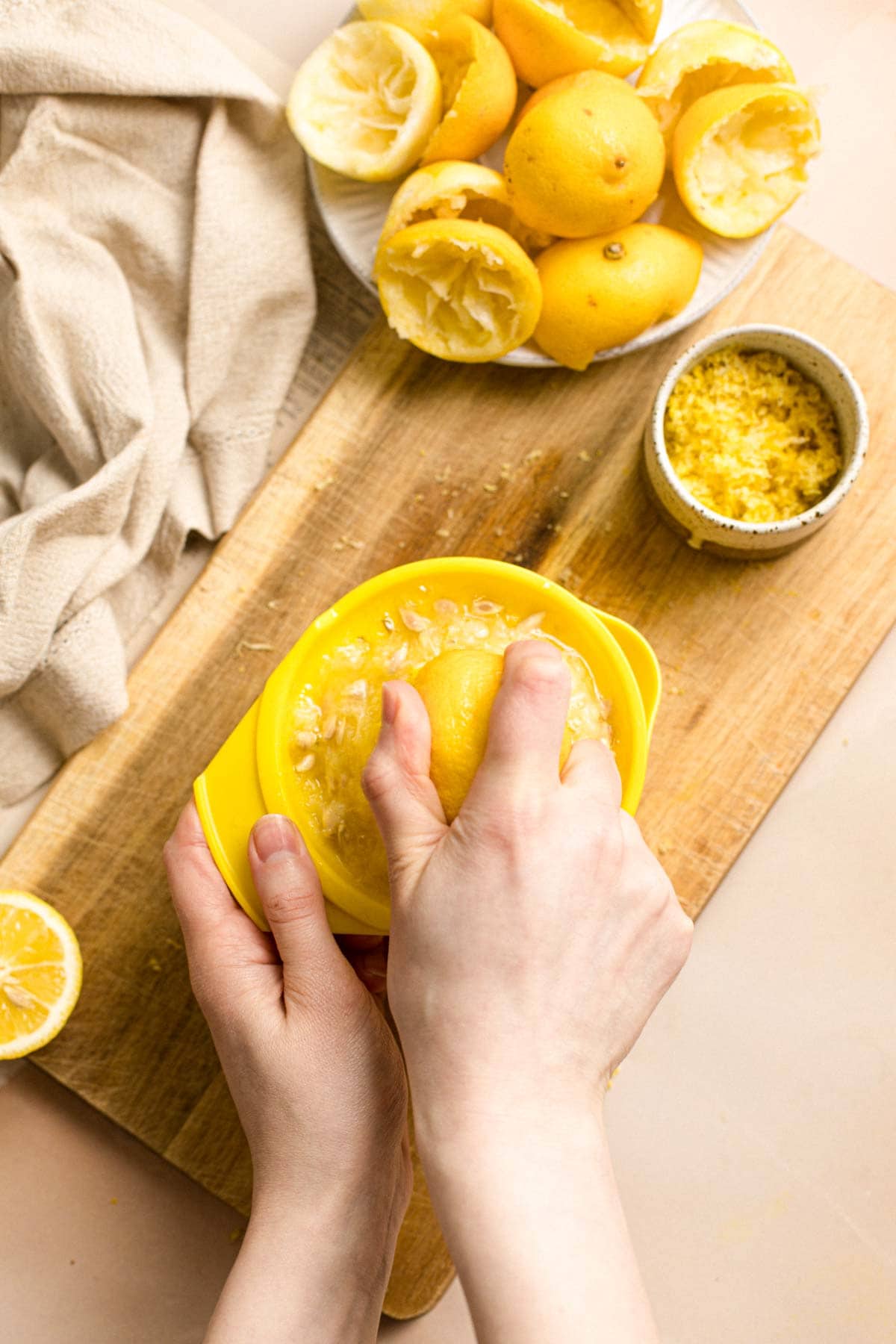 Two hands using a citrus juicer to juice lemons. 