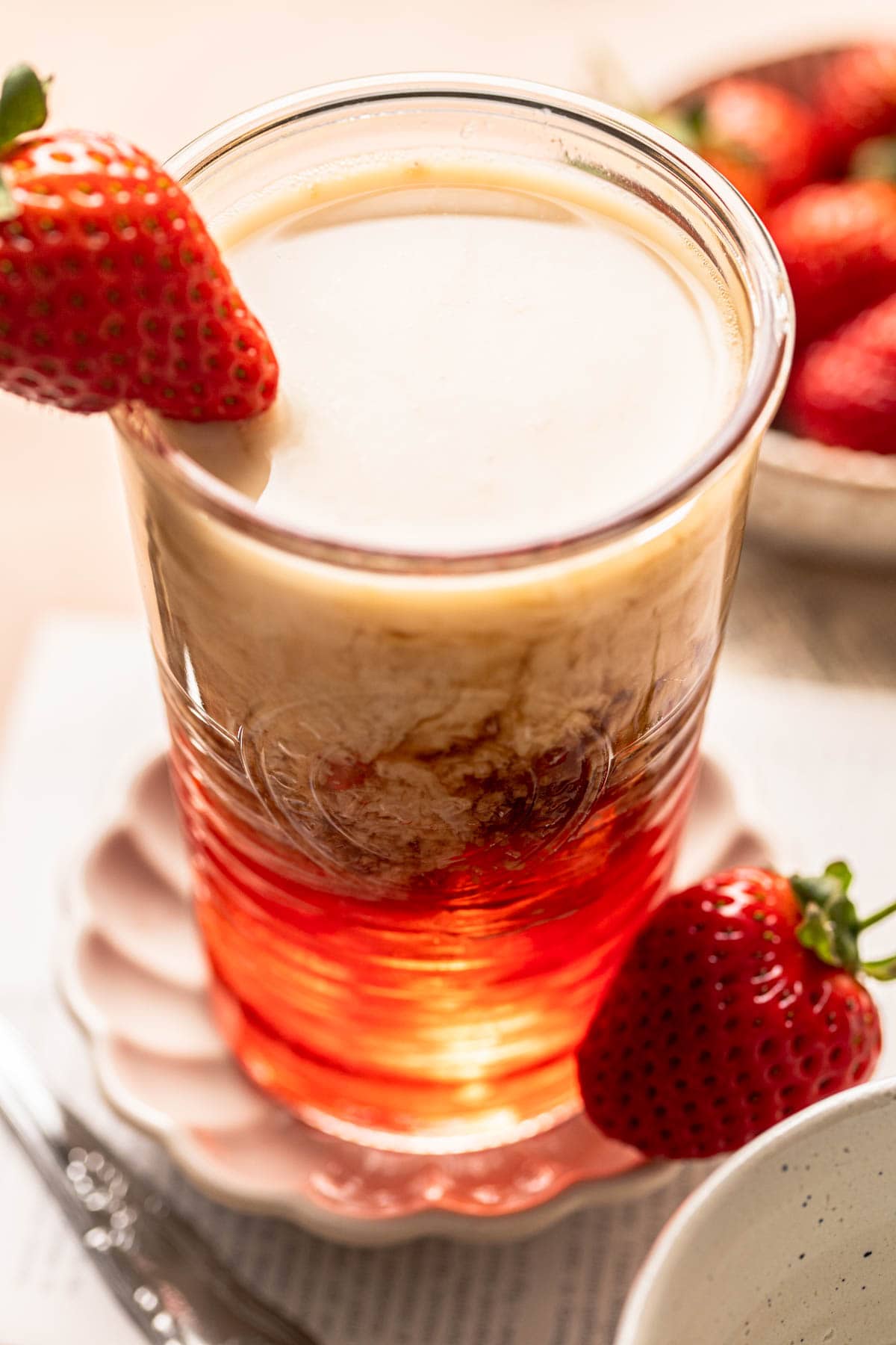 A side view of iced strawberry latte in a glass.